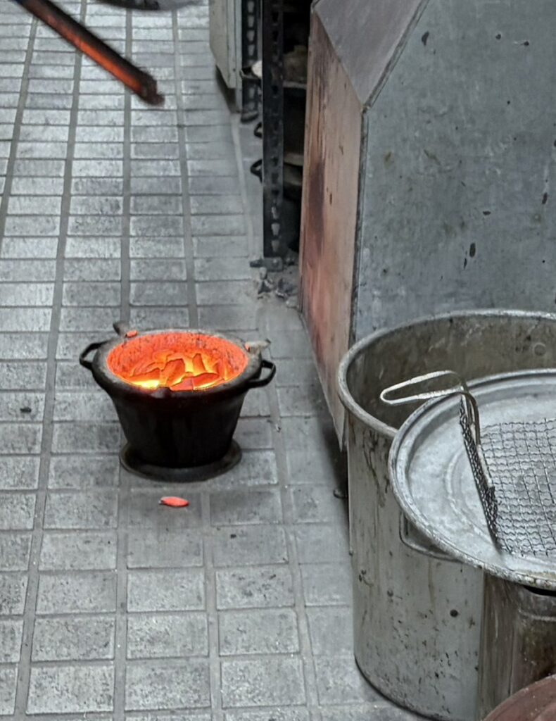 Stacked unlit charcoal braziers in Wonju’s Beef Alley