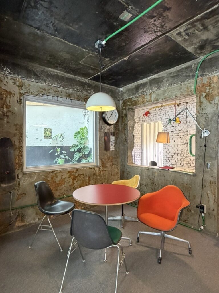 Industrial concrete interior room at Limited Coffee with colorful mismatched designer chairs