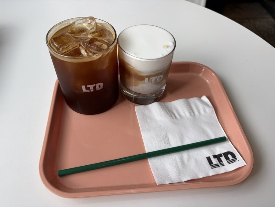 Iced coffee and cream latte served on a pink tray at Limited Coffee